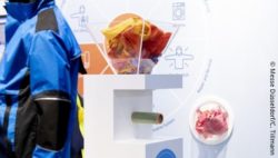Image: A container holding reusable materials placed next to a blue jacket; Copyright: Messe Düsseldorf/C. Tillmann