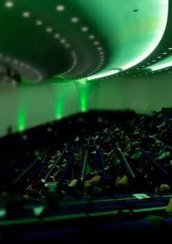 Foto: Ein Bild vom A+A Kongress. Man sieht die Bühne und die Menschen im Publikum.